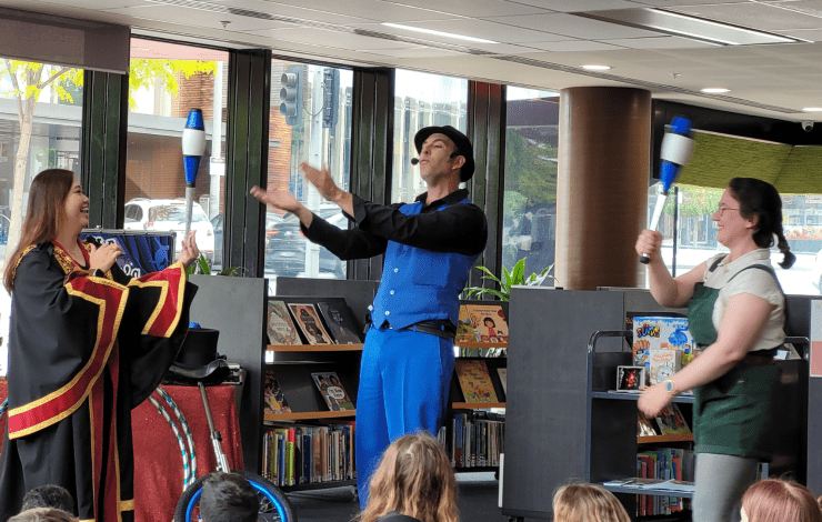 Mayor and Mr Marvel juggling in a library