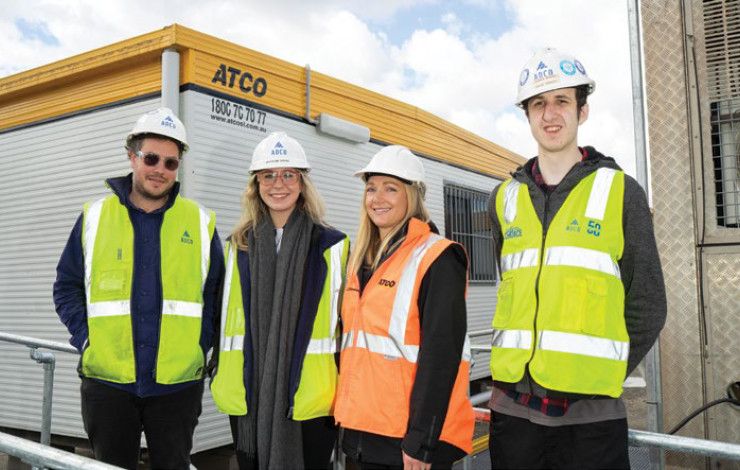 Four people smiling in visy vests