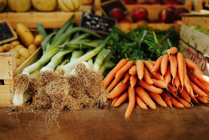 Fresh produce including carrots and leeks layed out on a table