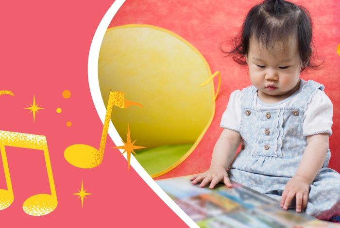 Seated toddler looking at a picture book. 