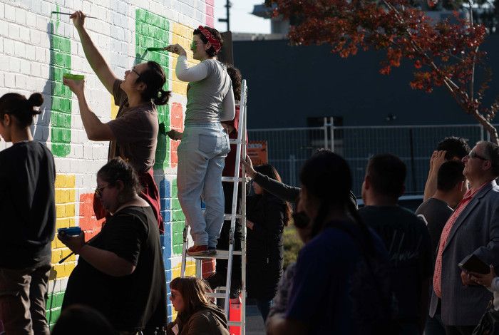 People watching people painting a mural