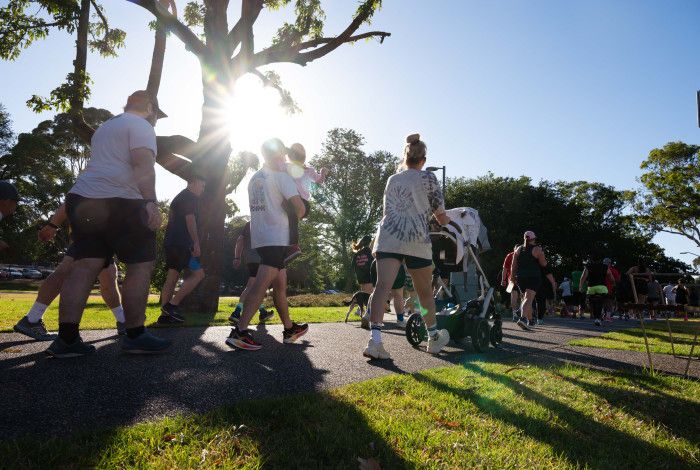 The backs of people walking in a park