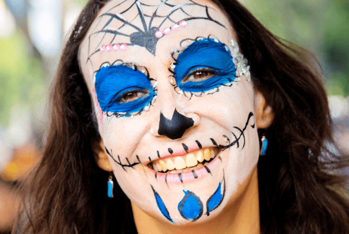 A woman with spiderweb facepainting on. 