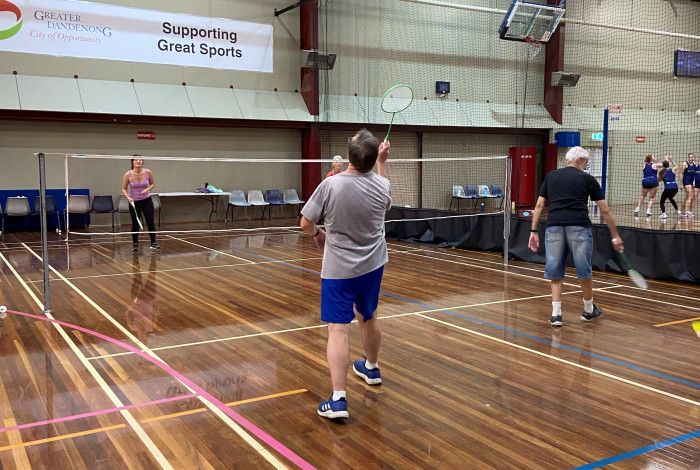 People playing badminton on an indoor court