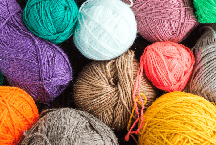 A pile of knitting yarn balls in bright colours.