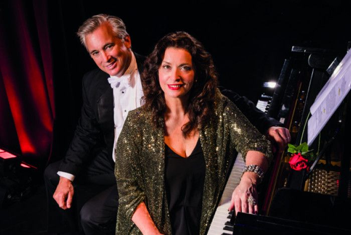 Lady and man sitting by a piano