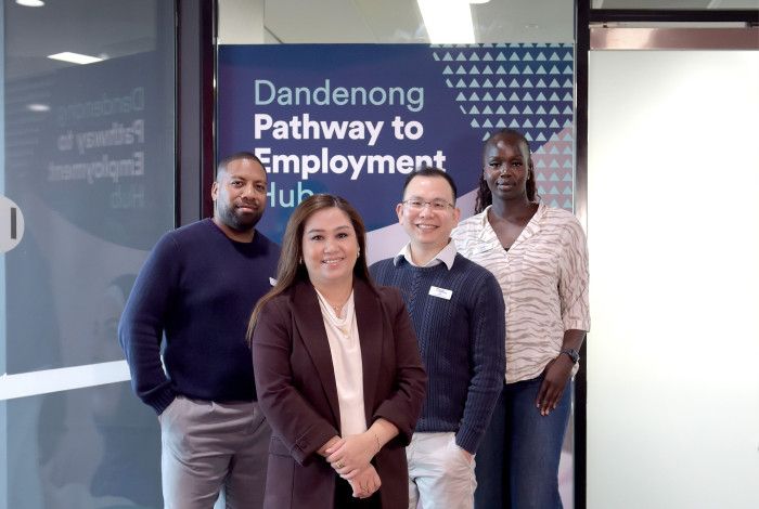 Four smiling people pose in front of a shop front with a sign that reads Dandenong Pathway to Employment Hub