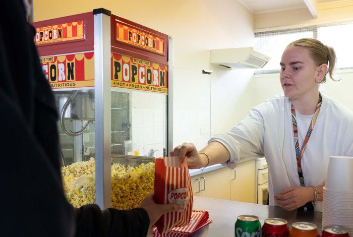 A staff member serving popcorn