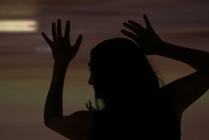 Silhouette of a woman with her hands up 