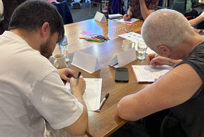 Two people writing at a workshop