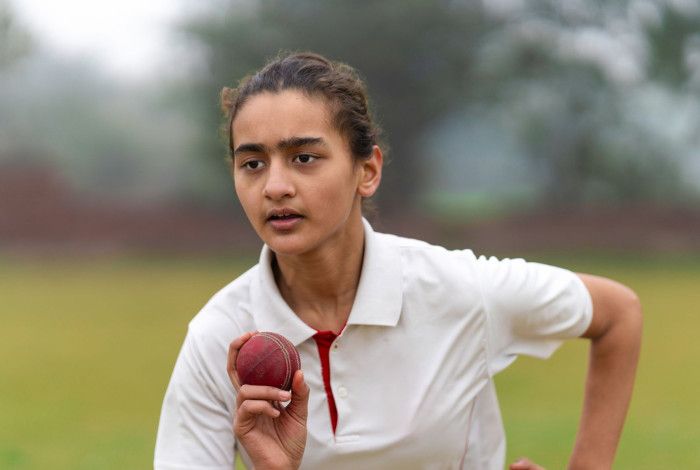 Girl throwing a cricket ball