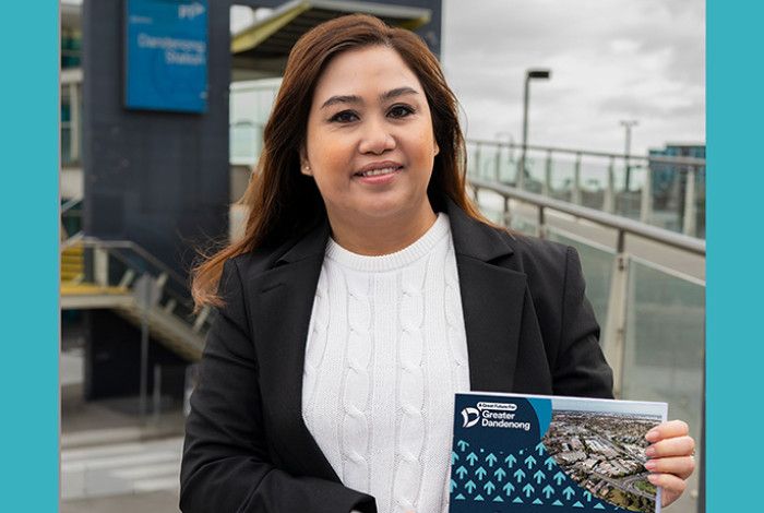 Councillor Sophie Tan holding a booklet A Great Future for Greater Dandenong
