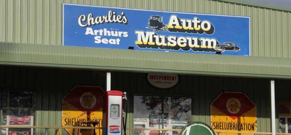 A sign on the front of the building advertising Charlie's Auto Museum