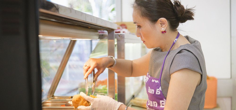 A lady preparing the Bánh Mì