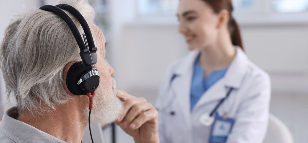 A healthcare professional testing a patient's ear in a medical office.
