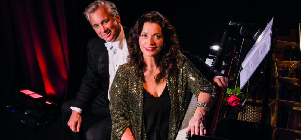 Lady and man sitting by a piano