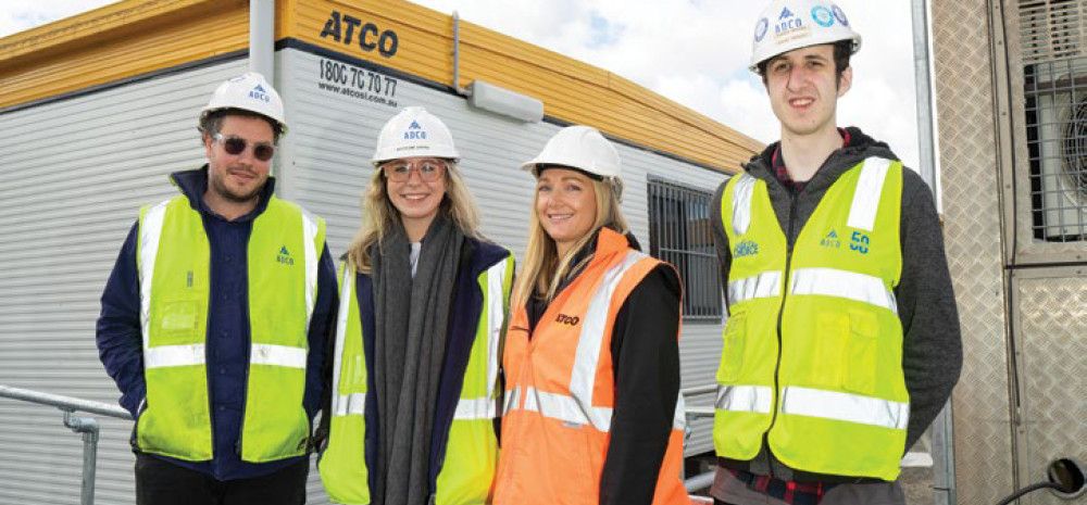 Four people smiling in visy vests