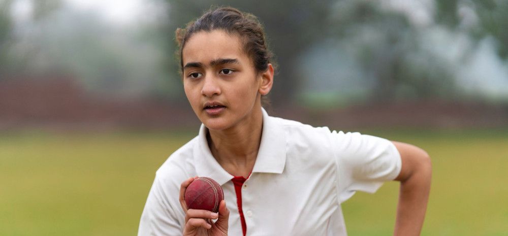 Girl throwing a cricket ball