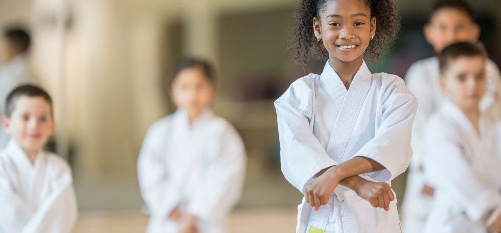 A girl smiling doing karate