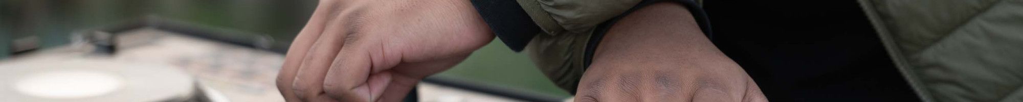 Hands working a turntable music mixing desk