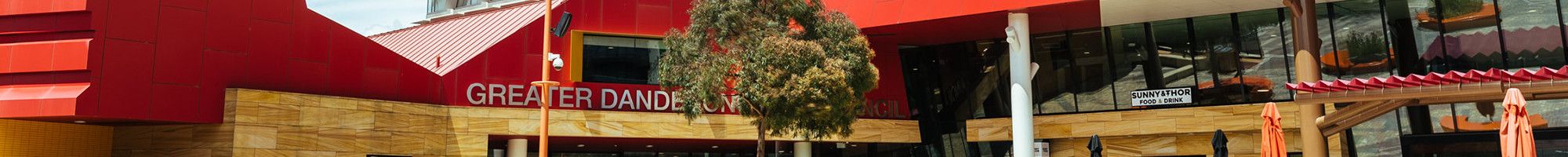 A colourful office building against a cloud and blue sky background