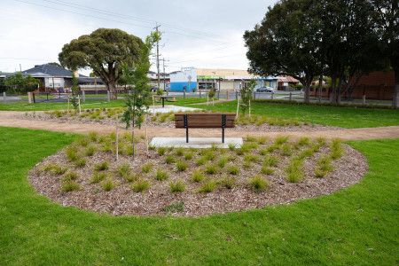 Overlooking a park bench in the middle of a grassy park