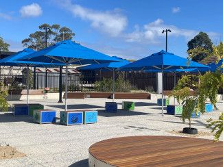Landscaped area with tables and umbrellas.