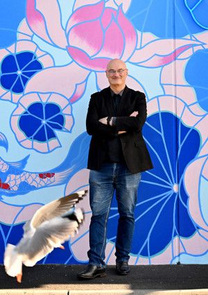 Cr Sean O'Reilly standing in front of a mural
